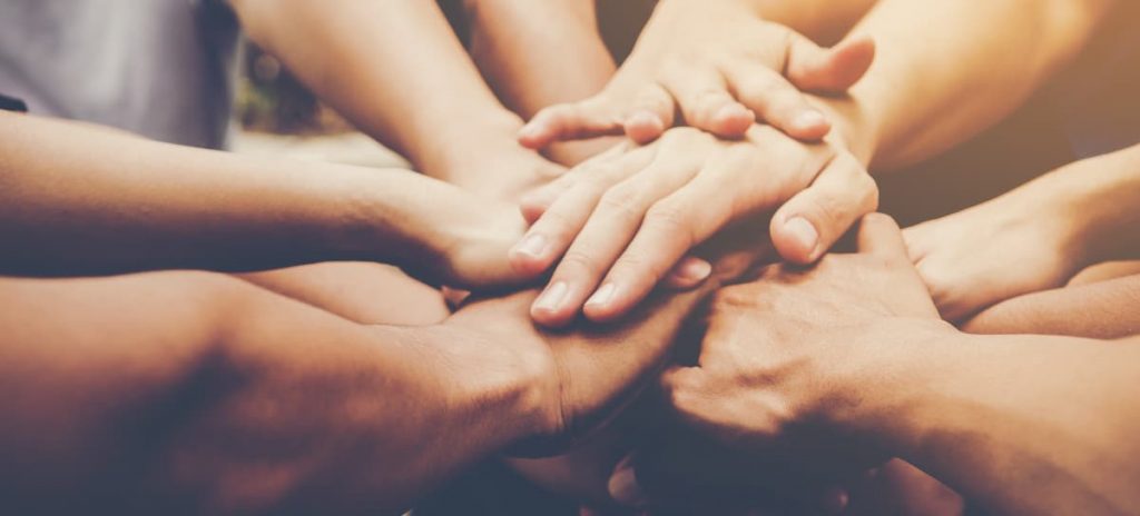 Grupos com as mãos sobrepostas.