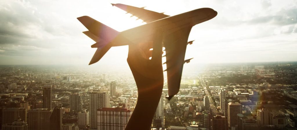 Foto de um avião voando, com um braço segurando... Imagem demonstrativa.