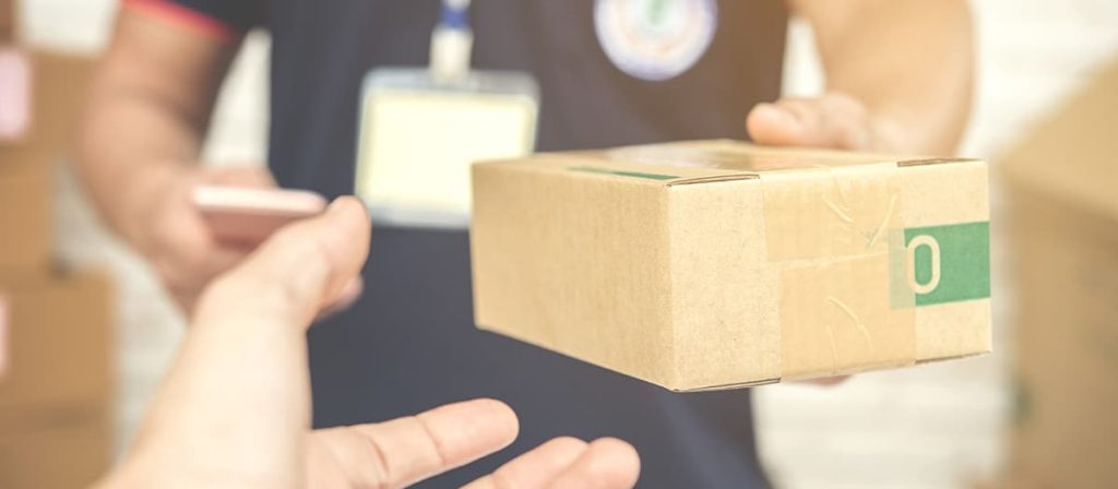 Homem entregando caixa de mercadoria, está conferindo.