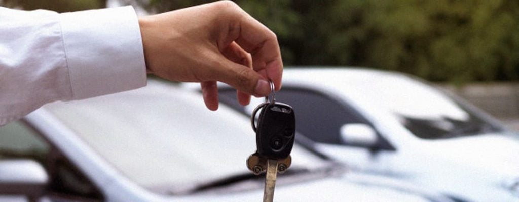 Pessoa segurando a chave de um carro.
